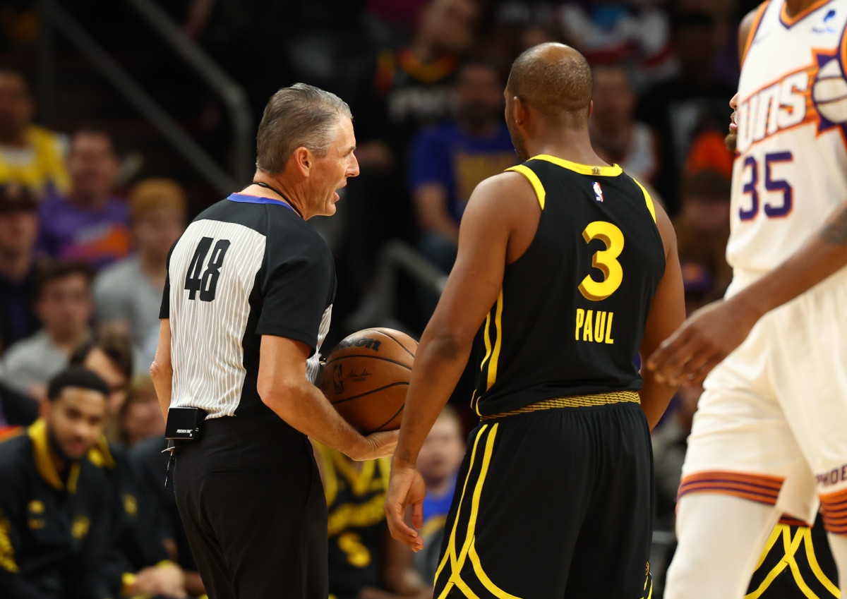 Chris Paul stands facing Scott Foster who holds the basketball